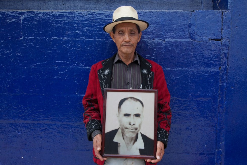 An Ixil Mayann man holds a photo of his father, who was killed in the 1980's by the Guatemalan military.