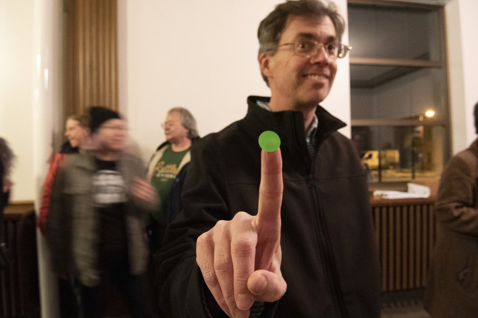 A voter receives his green dot allowing him to enter the caucus area and align with a candidate.