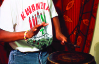 Description-_Young_man_playing_drums_during_Kwanzaa_celebration,_three-quarter_length_portrait._(2536626922).jpg